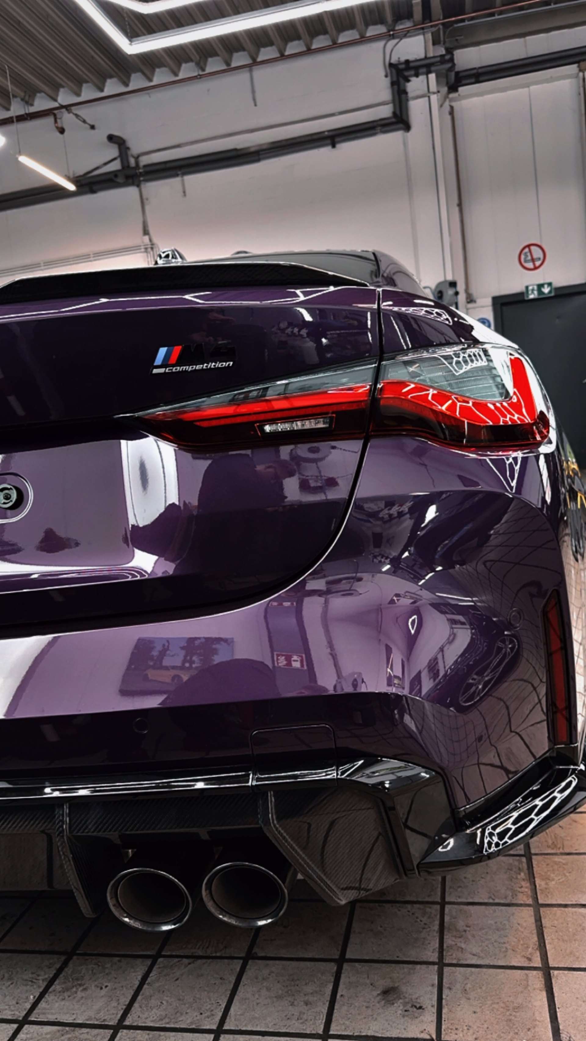 Glänzendes Heck eines violetten BMW M4 in der Veredelungshalle von Care Performance