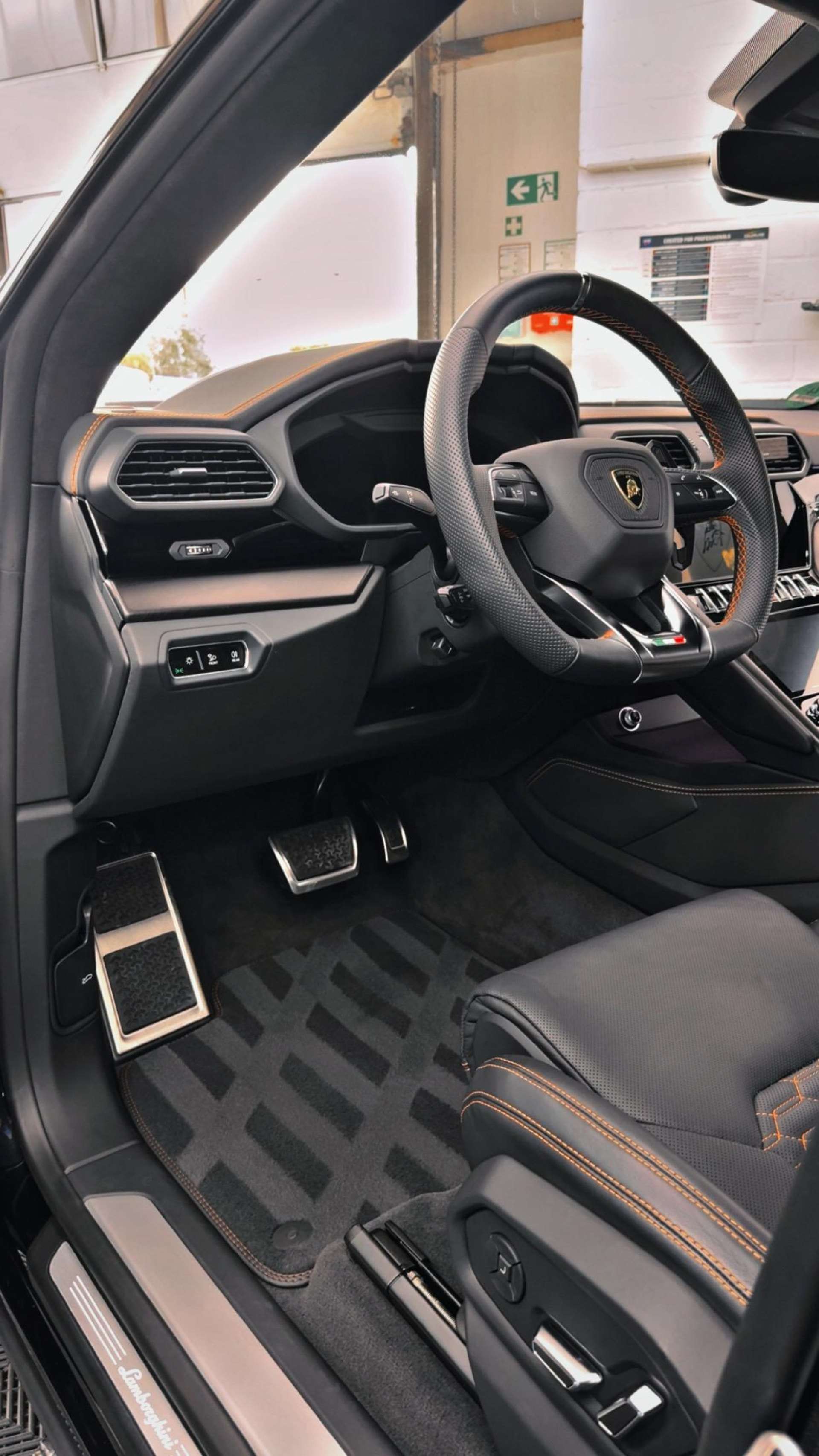 Cockpit eines Lamborghini mit Lenkrad, Mittelkonsole und Lederausstattung in der Halle von Care Performance