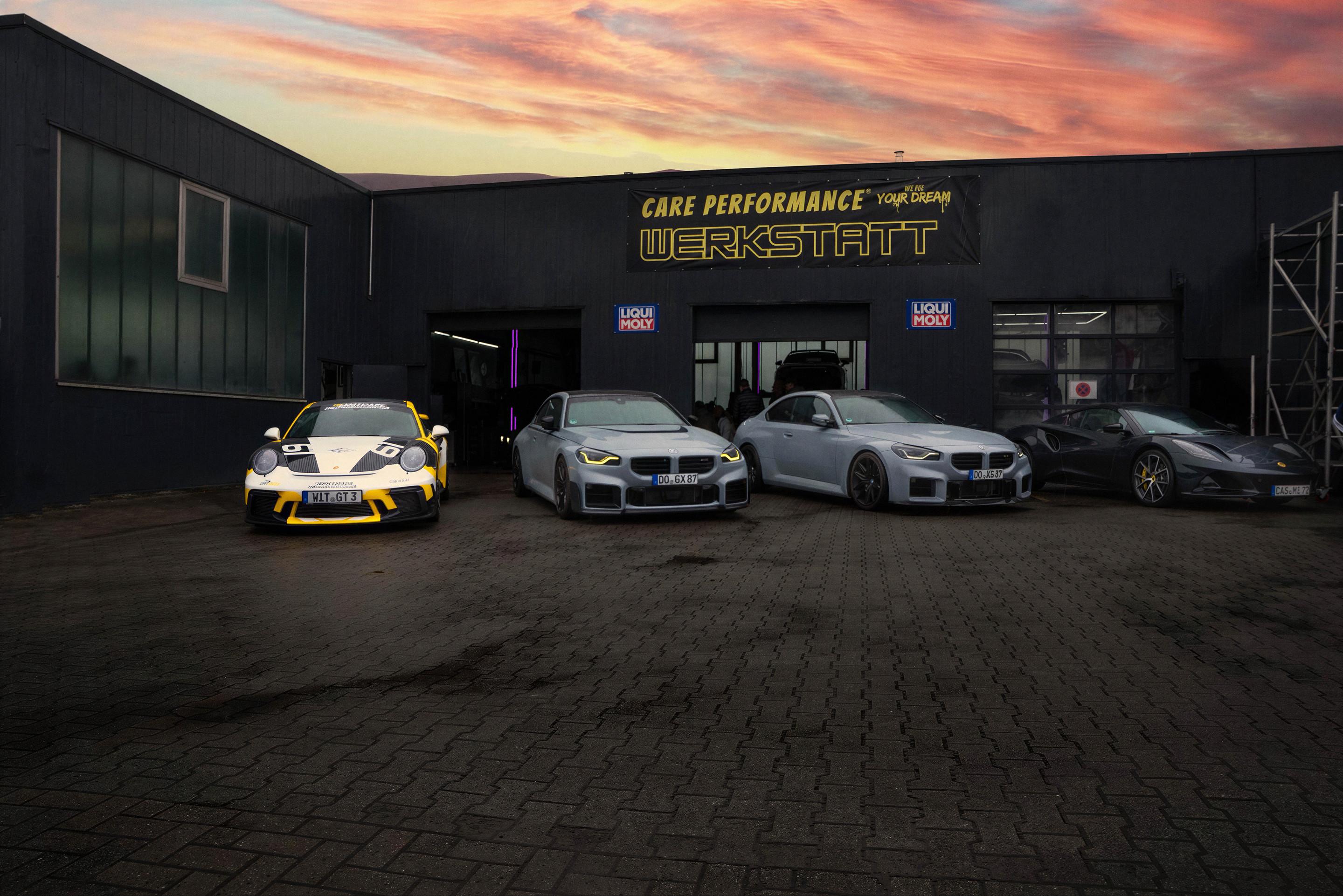 Die Halle von Care Performance an der Evinger Straße in der Abendsonne, davor vier Sportwagen